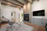 This modern living space features a cozy fireplace with a rustic wood accent wall, perfect for gathering.