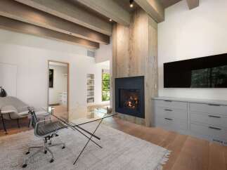 This modern living space features a cozy fireplace with a rustic wood accent wall, perfect for gathering.