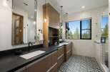 Experience modern luxury in this stunning bathroom featuring a dual vanity with sleek black countertops and rich wood cabinetry.