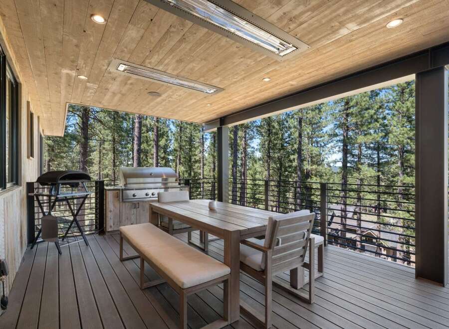 Enjoy outdoor living at its finest on this expansive deck, complete with a built-in grill and comfortable dining set.