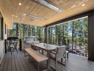 Enjoy outdoor living at its finest on this expansive deck, complete with a built-in grill and comfortable dining set.