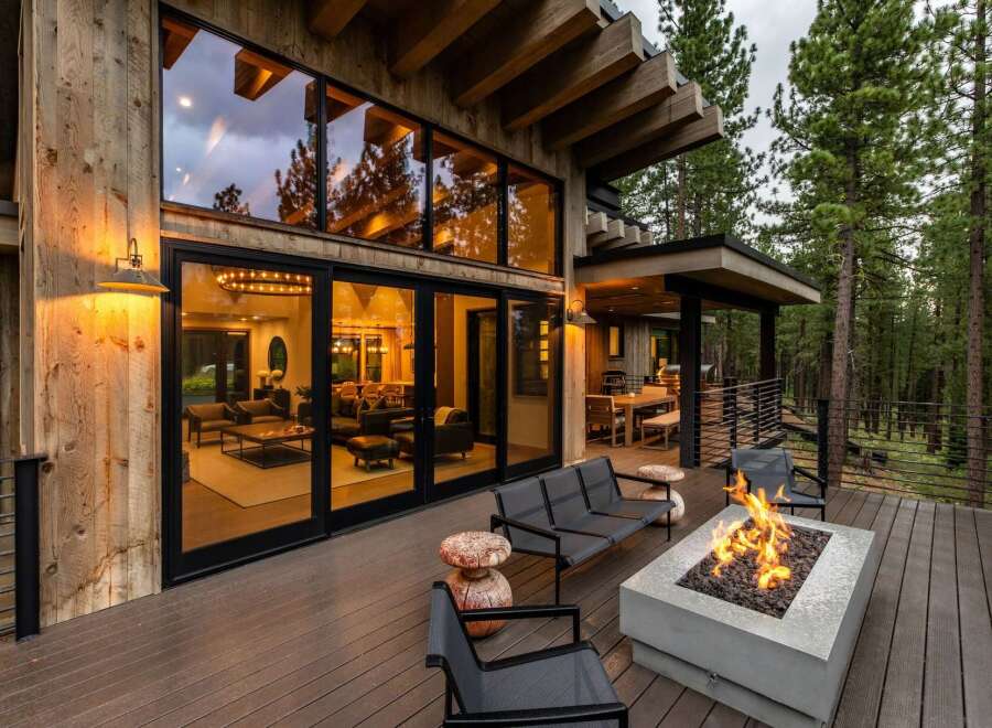 Experience luxury mountain living with this stunning modern cabin featuring expansive floor-to-ceiling windows that showcase breathtaking forest views.