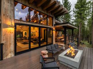 Experience luxury mountain living with this stunning modern cabin featuring expansive floor-to-ceiling windows that showcase breathtaking forest views.