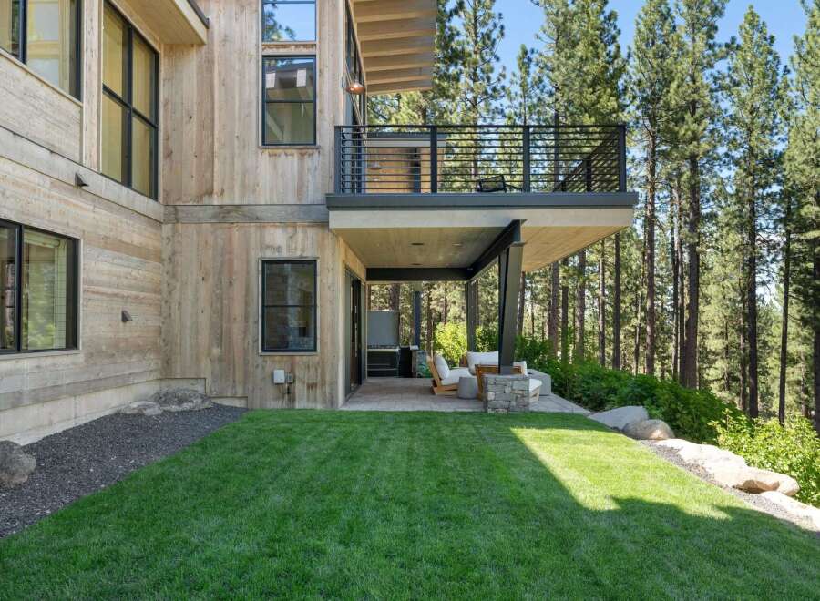 Experience modern mountain living in this stunning home, featuring natural wood siding and expansive windows that seamlessly blend indoor and outdoor spaces.