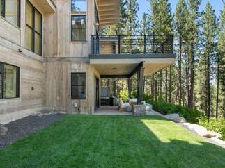 Experience modern mountain living in this stunning home, featuring natural wood siding and expansive windows that seamlessly blend indoor and outdoor spaces.