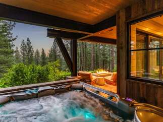 Indulge in ultimate relaxation with this luxurious outdoor living space, featuring a steaming hot tub perfect for unwinding.