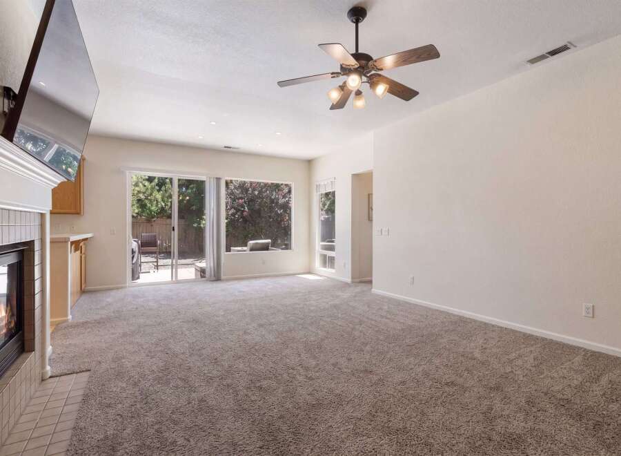 Experience cozy evenings by the fireplace in this inviting living room, featuring a large TV mounted above the mantle.