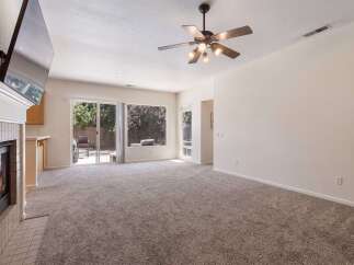 Experience cozy evenings by the fireplace in this inviting living room, featuring a large TV mounted above the mantle.