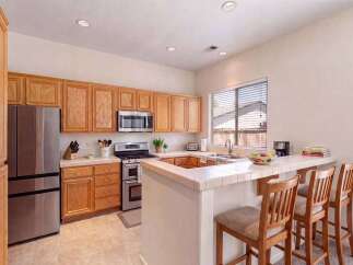 Discover this charming kitchen featuring warm wood cabinetry and a convenient breakfast bar perfect for casual dining.