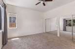 This spacious bedroom features plush carpeting and ample natural light streaming in from the large windows.