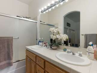 This bright bathroom features a spacious double vanity with two sinks and ample counter space, perfect for busy mornings.