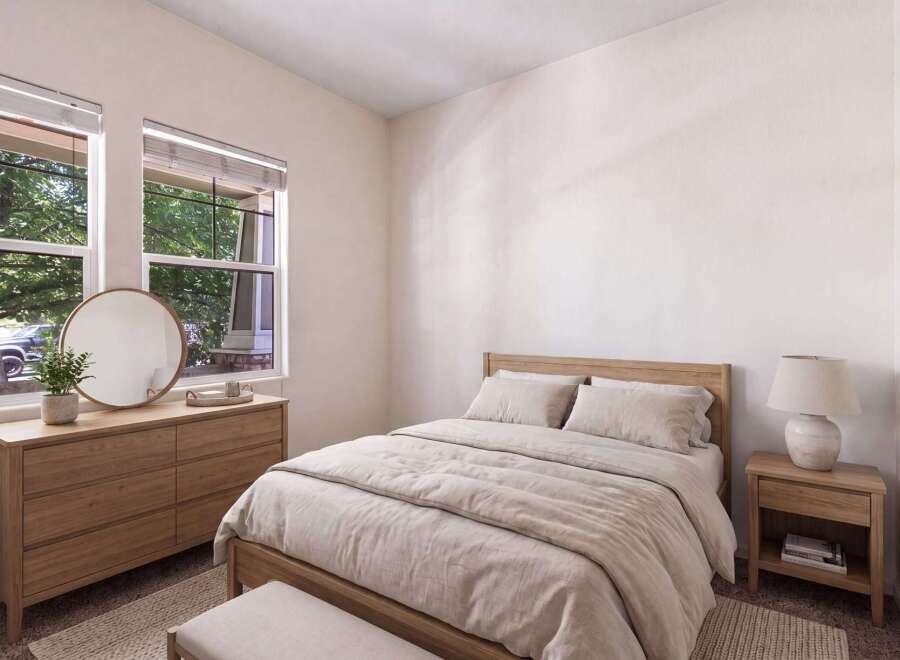 This beautifully staged bedroom features a cozy queen-size bed with natural linen bedding, complemented by a light wood dresser and a round mirror.