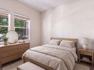 This beautifully staged bedroom features a cozy queen-size bed with natural linen bedding, complemented by a light wood dresser and a round mirror.