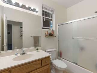 This bathroom features a spacious vanity with a large mirror and ample lighting, perfect for your morning routine.
