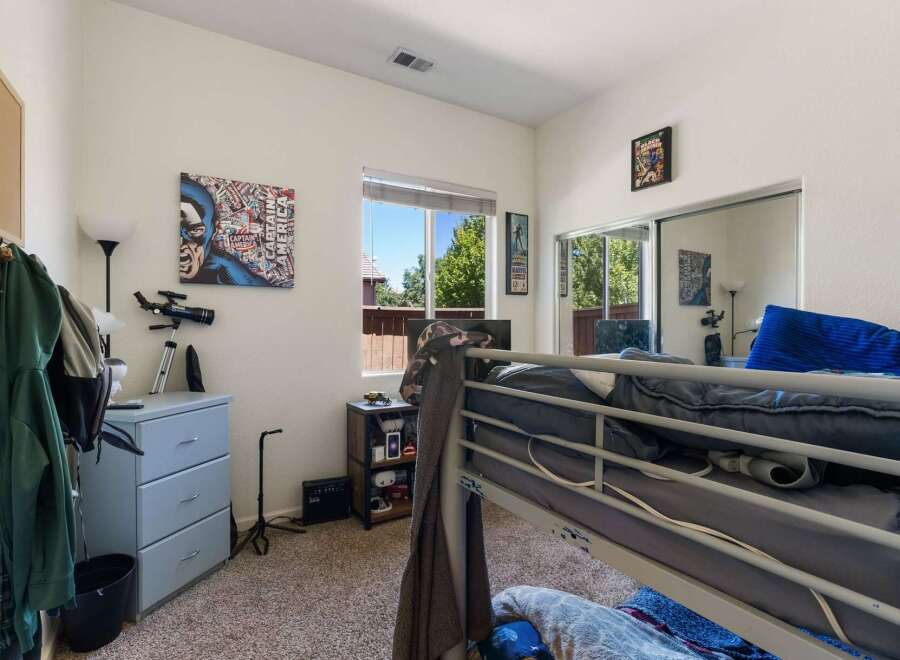 This bedroom features a fun Captain America-themed wall art and a telescope, perfect for a young enthusiast.