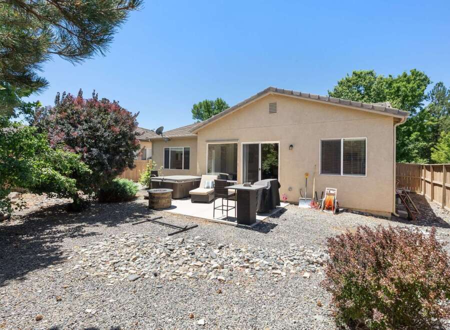 Enjoy outdoor living in this spacious backyard featuring a relaxing hot tub and a built-in grill perfect for entertaining.