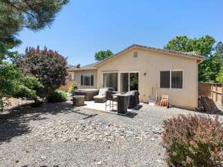 Enjoy outdoor living in this spacious backyard featuring a relaxing hot tub and a built-in grill perfect for entertaining.