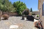 Enjoy outdoor living in this spacious backyard, featuring a covered grill area perfect for summer cookouts.