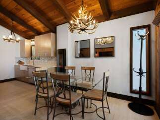 Experience rustic charm in this dining area featuring a striking antler chandelier that illuminates the space.