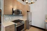 Discover this modern kitchen featuring sleek, light wood cabinetry and a stylish hexagonal tile backsplash.