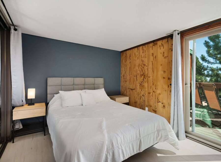 Experience serene living in this charming bedroom featuring a comfortable queen-size bed with a plush headboard and crisp white linens.