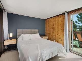 Experience serene living in this charming bedroom featuring a comfortable queen-size bed with a plush headboard and crisp white linens.