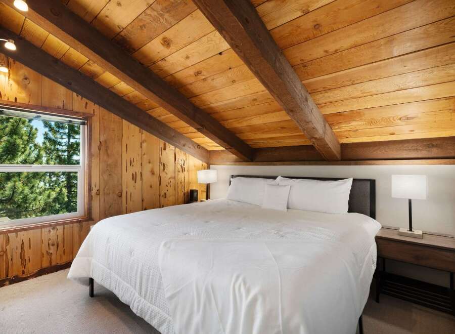 Experience rustic charm in this cozy bedroom featuring a plush king-sized bed with crisp white linens.