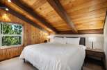 Experience rustic charm in this cozy bedroom featuring a plush king-sized bed with crisp white linens.