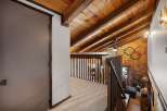 Experience rustic charm with this stunning loft featuring a vaulted wood-paneled ceiling and exposed beams, creating a warm and inviting atmosphere.