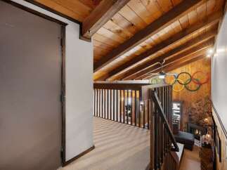 Experience rustic charm with this stunning loft featuring a vaulted wood-paneled ceiling and exposed beams, creating a warm and inviting atmosphere.
