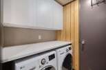 This laundry room features a convenient built-in countertop perfect for folding clothes, situated above a matching LG washer and dryer set.