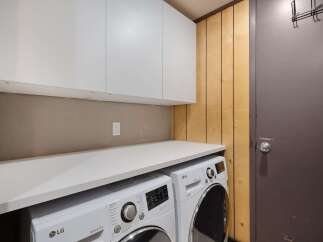 This laundry room features a convenient built-in countertop perfect for folding clothes, situated above a matching LG washer and dryer set.
