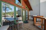 Enjoy outdoor living on this charming wooden deck, complete with a dining table and chairs perfect for al fresco meals.