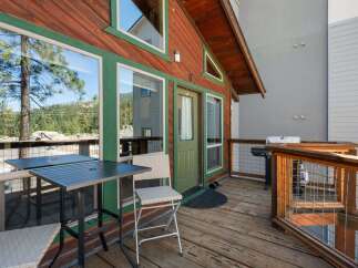 Enjoy outdoor living on this charming wooden deck, complete with a dining table and chairs perfect for al fresco meals.