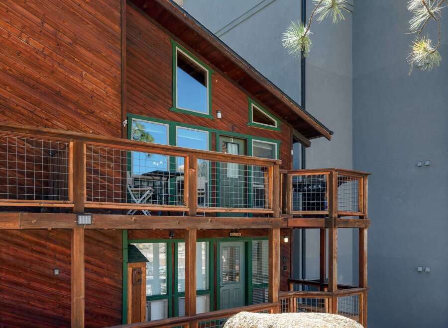Experience rustic charm and modern comfort in this multi-level wooden cabin, featuring expansive decks with wire railings perfect for outdoor living.