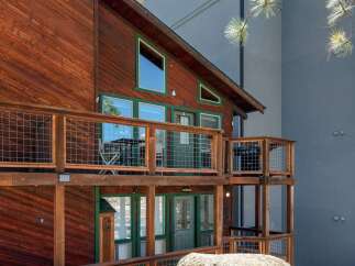 Experience rustic charm and modern comfort in this multi-level wooden cabin, featuring expansive decks with wire railings perfect for outdoor living.