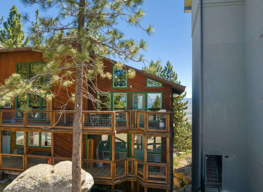 Experience breathtaking mountain views from this stunning wooden home, featuring multiple levels of expansive decks perfect for outdoor entertaining.