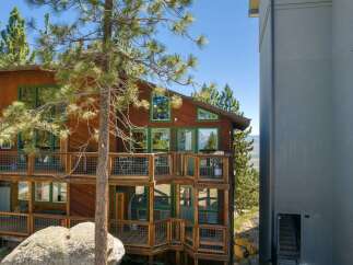 Experience breathtaking mountain views from this stunning wooden home, featuring multiple levels of expansive decks perfect for outdoor entertaining.