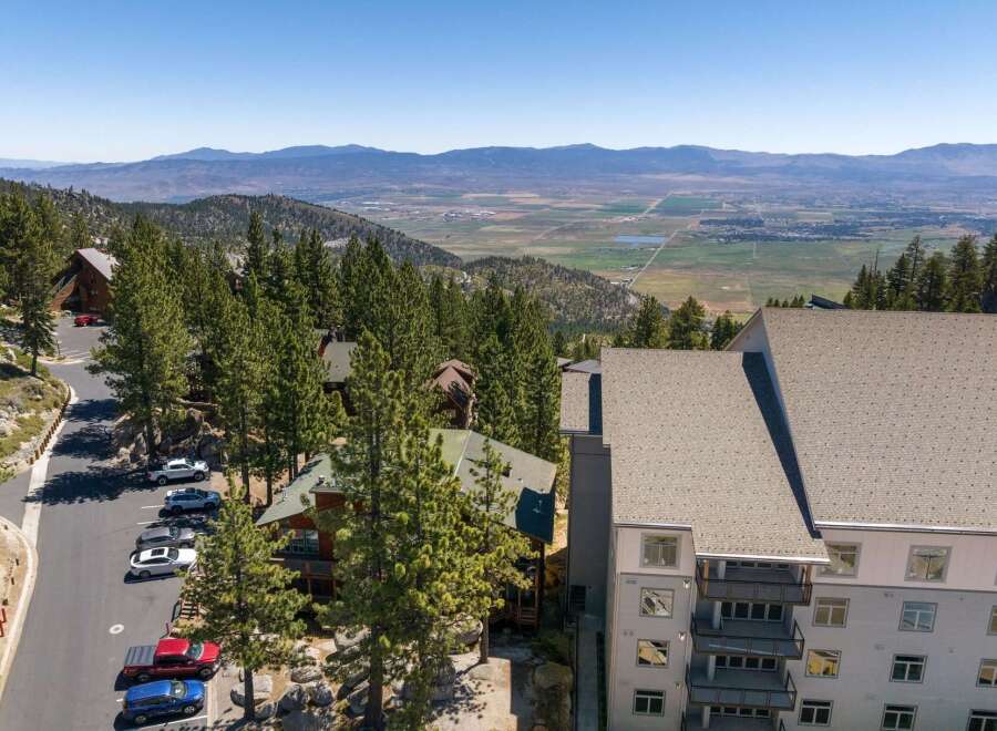 Experience breathtaking mountain views from this stunning property, nestled amidst tall pine trees.