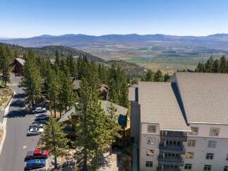 Experience breathtaking mountain views from this stunning property, nestled amidst tall pine trees.