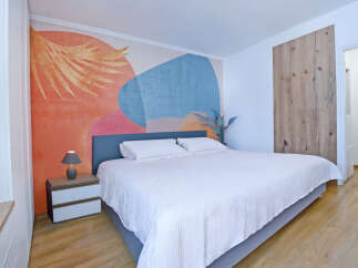 Experience modern comfort in this beautifully appointed bedroom, featuring a striking abstract mural that adds a vibrant pop of color to the space.
