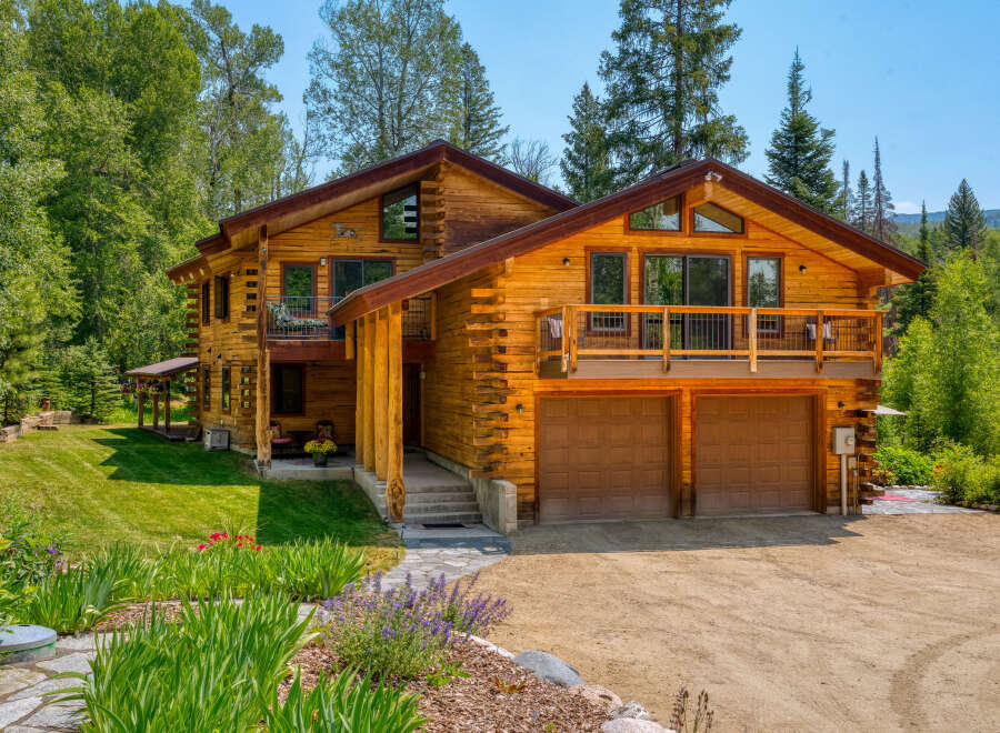 Experience rustic luxury in this stunning log home, nestled amidst lush greenery and mature trees.