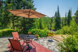 Enjoy outdoor living on this charming patio featuring a round metal table with two chairs and a large umbrella, perfect for al fresco dining.