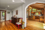 Step into a charming home featuring a spacious open-concept living area with a stunning vaulted ceiling and exposed wooden beams.