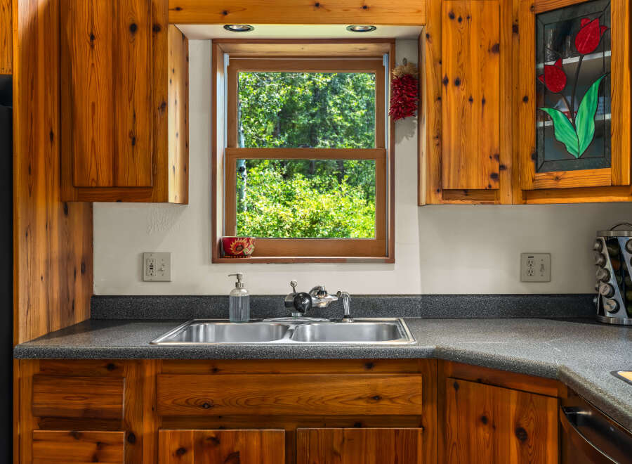 This charming kitchen features warm, knotty pine cabinetry that adds a rustic touch.