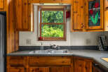This charming kitchen features warm, knotty pine cabinetry that adds a rustic touch.