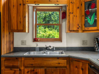 This charming kitchen features warm, knotty pine cabinetry that adds a rustic touch.