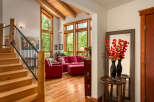 Experience rustic charm in this inviting living space featuring a grand wooden staircase and exposed beam ceiling.
