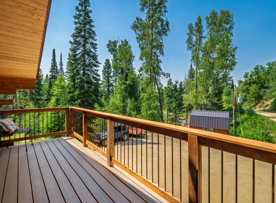 Enjoy the serene mountain views from this charming log cabin's spacious deck.