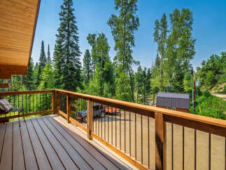 Enjoy the serene mountain views from this charming log cabin's spacious deck.